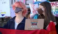 People hold a sign that reads 'Encourage love not hate at SDA + everywhere'