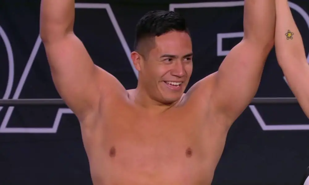 Jake Atlas holds up his arms in triumph after winning his debut match with All Elite Wrestling