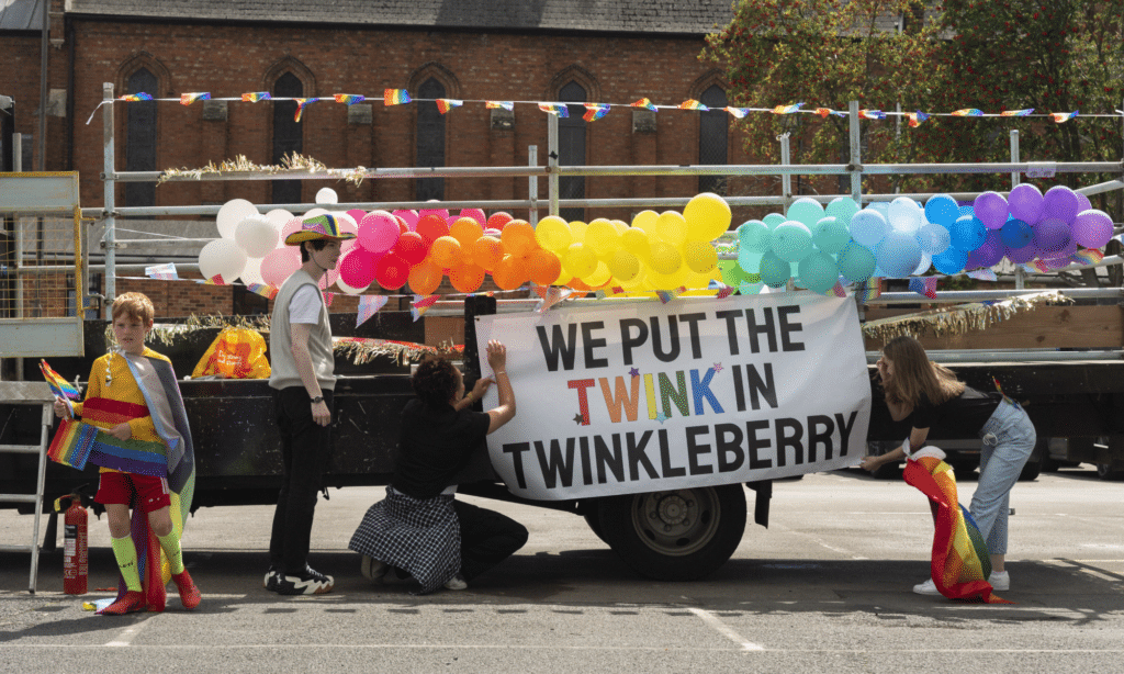 A Pride float with a banner reading 'we put the twink in Twinkleberry'