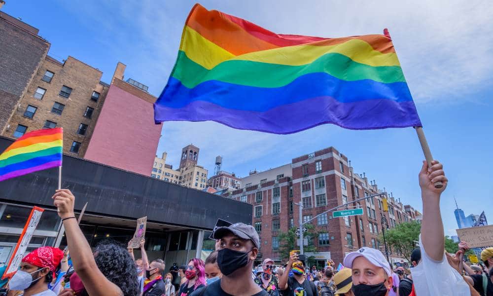 Participants hold LGBT+ rainbow flags during the second annual Queer Liberation March