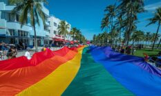 A rainbow flag flies over Ocean Drive as people participate in a Pride parade at a Pride festival in Florida
