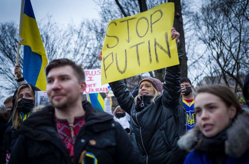 Activists hold placards and flags as they gather in Lafayette Square to protest Russia's invasion of Ukraine in Washington, DC.