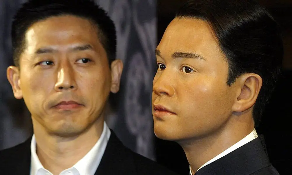 Daffy Tong, partner of Leslie Cheung, looks at a waxwork of the late singer and actor