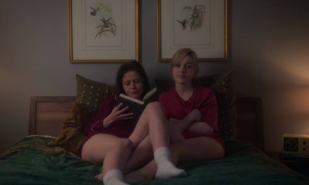 Jamie and Dani, two white women, are seen snuggling on a bed