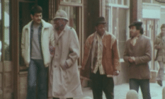 Four Black men walking a street in the 80s