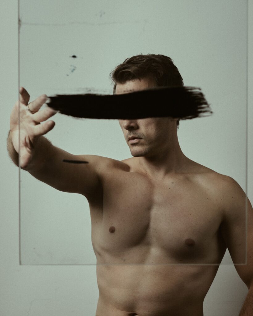 Topless man with his eyes covered by a black streak