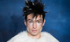 Actor Ezra Miller is seen wearing a white fluffy outfit with silver makeup and fluffy dark hair with white tips