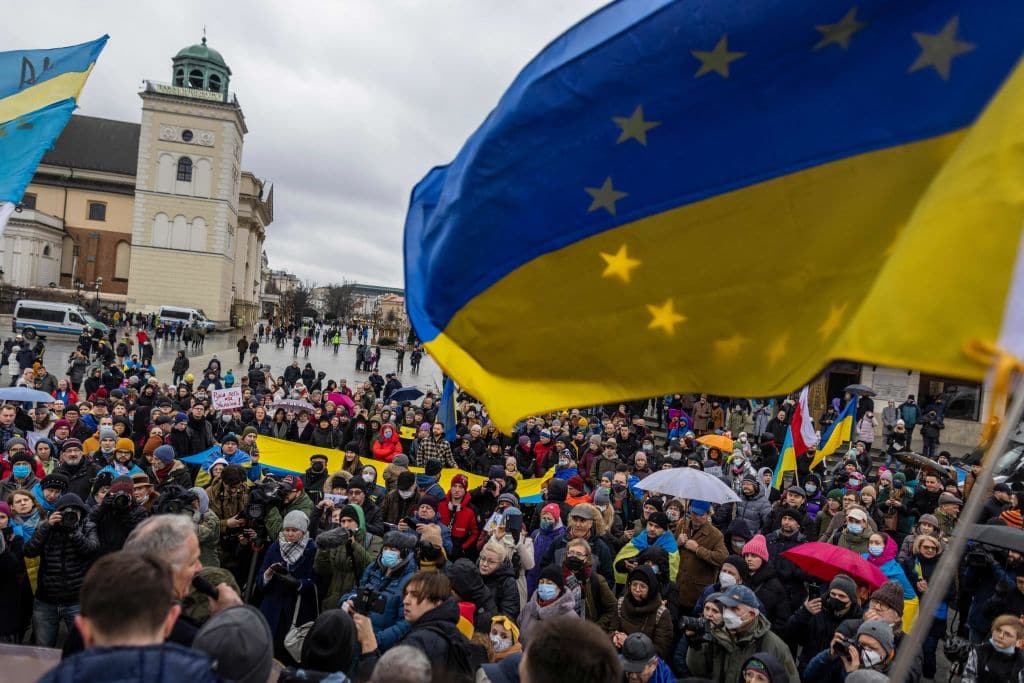 Protesters wave Ukrainian flags during a demonstration for peace in Ukraine, in Warsaw, Poland. 