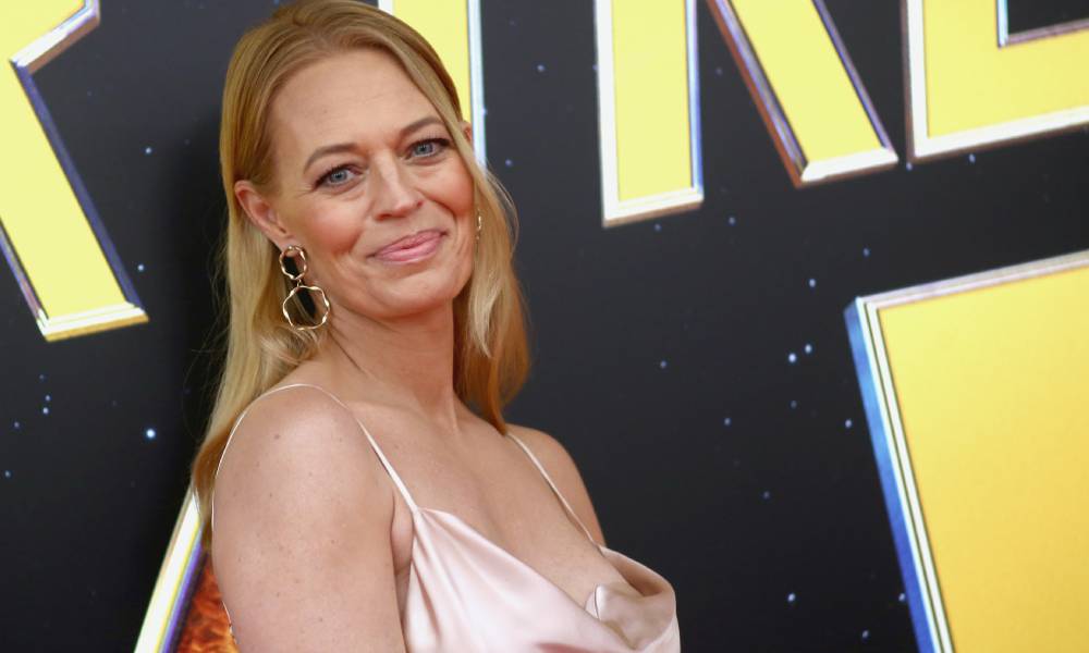 Jeri Ryan wears a champagne colour silk top with the words Star Trek in the background