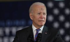 Joe Biden, the president of the United States, stands at a podium with an American flag in the background