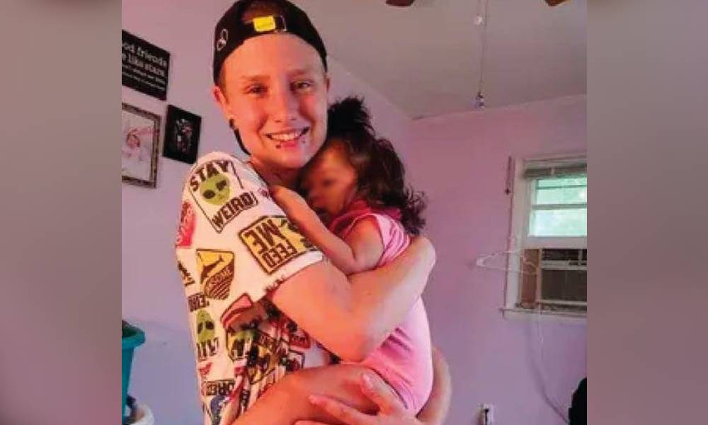 Matthew Angelo Spampinato, a white trans man, is seen holding a small child