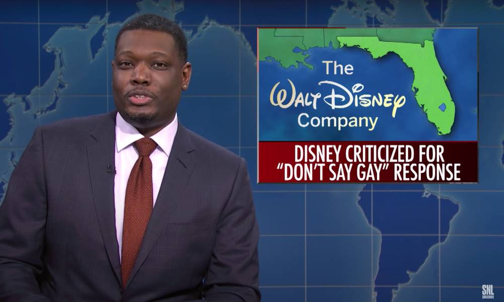 SNL castmate Michael Che during the Weekend Update segment with a picture of Florida alongside the Walt Disney Company logo and a news bulletin about the state's "Don't Say Gay" bill