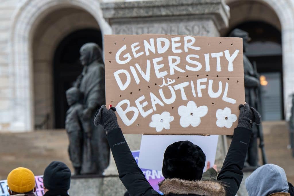 A protester holding a sign reading "gender diversity is beautiful