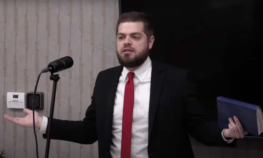 Jonathan Shelley preaching in a suit