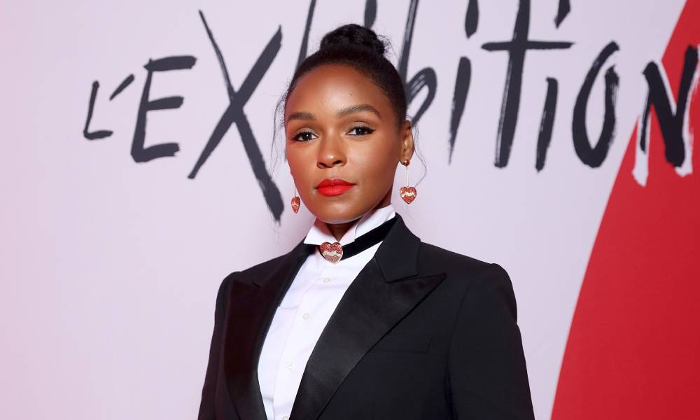 Janelle Monáe wears a black suit jacket, white shirt and collar