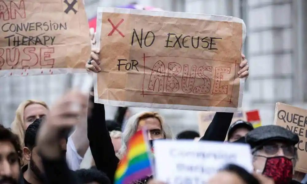 A protester holds a placard saying "No excuse for abuse" during a demonstration against conversion therapy outside UK Cabinet office
