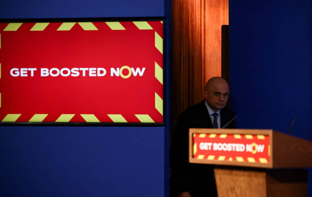 Sajid Javid standing beside a podium at a COVID-19 press conference