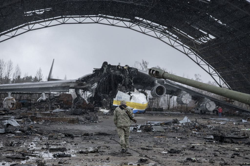 A Ukrainian serviceman walks near by the wreckage of a cargo aircraft amid the destruction at the military airport in the town of Hostomel, on the outskirts of Kyiv. 