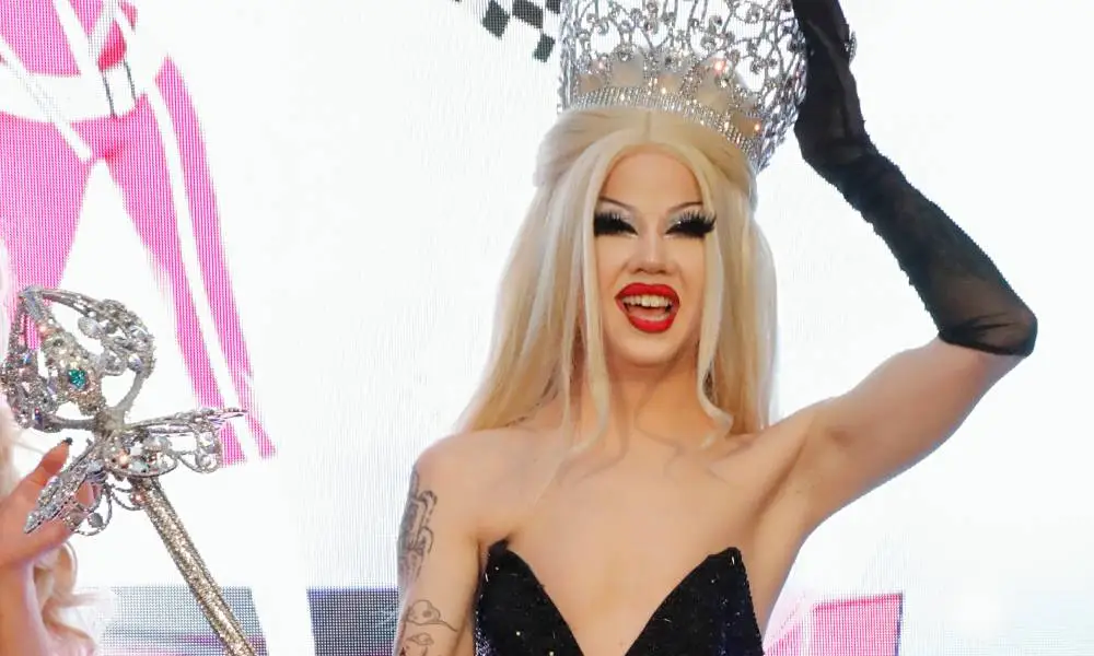 Willow Pill smiles and holds up their crown and sceptre as they are crowned the winner of Drag Race season 14