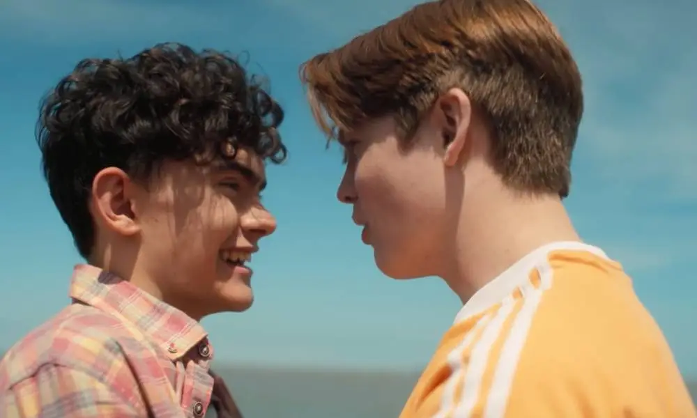 A still of Heartstopper characters Charlie and Nick on the beach from the Netflix show