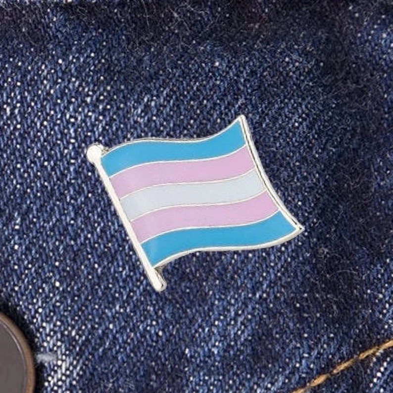 Trans Pride flag pin.