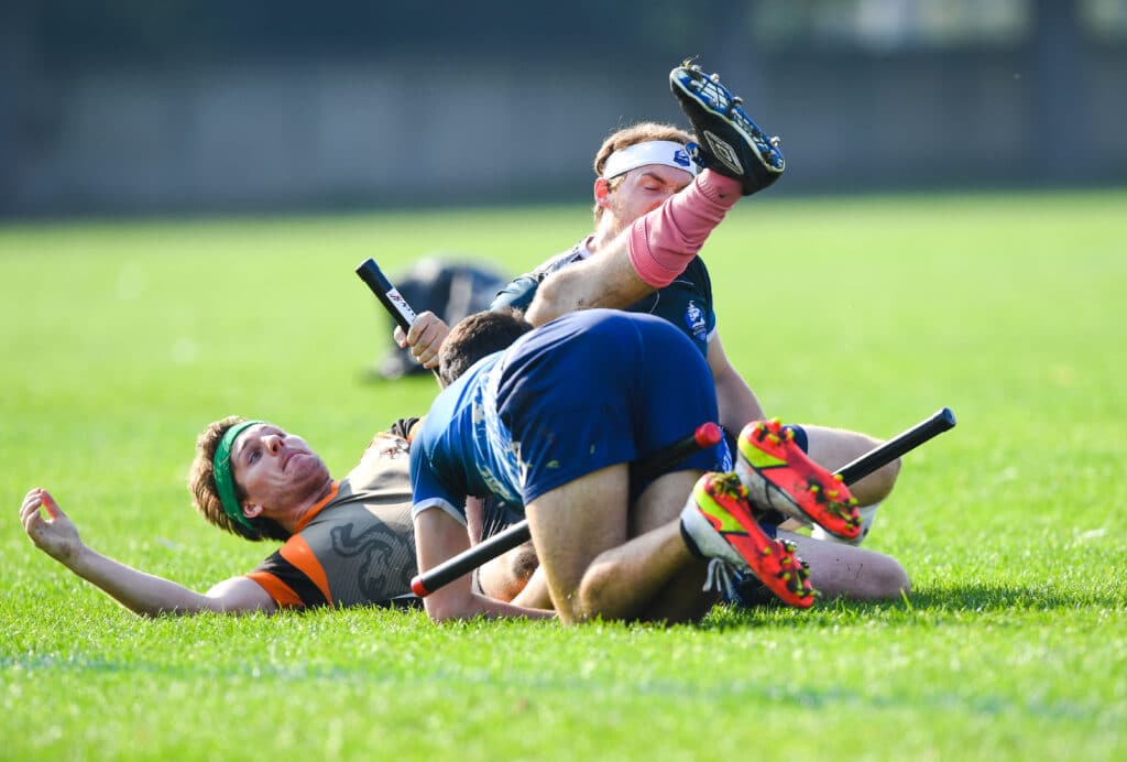 Four quidditch players in a heap on the ground
