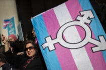Activists hold a trans Pride flag