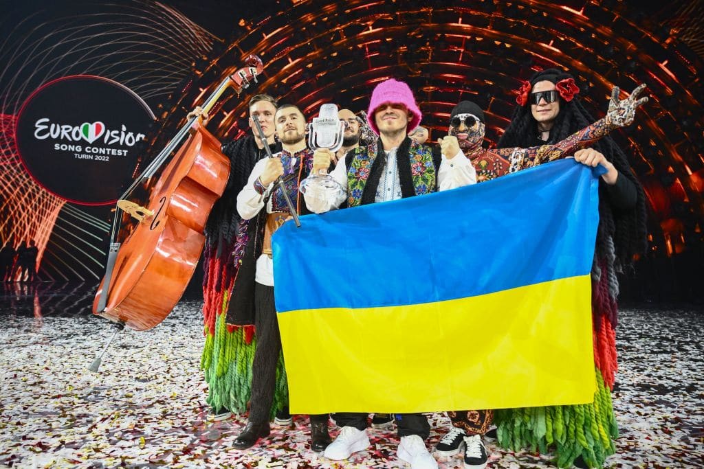 Kalush Orchestra pose onstage with the winner's trophy and Ukraine's flags after winning on behalf of Ukraine the Eurovision Song contest