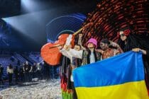 Kalush Orchestra hold the Eurovision trophy and a Ukraine flag