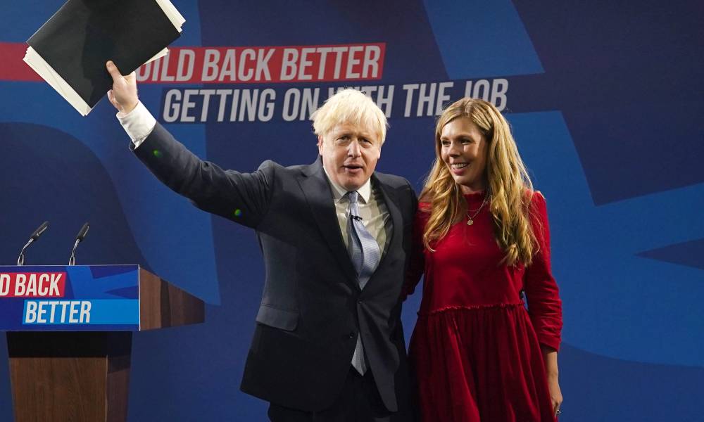 Carrie Johnson stands alongside her husband prime minister Boris Johnson as they stand on stage during an event