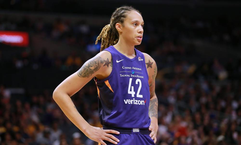 Brittney Griner wears a purple Phoenix Mercury jersey with the #42 on it. She is standing by during free throws during a WNBA basketball game.