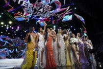 Contestants stand over the Miss International Queen 2022 Transgender Beauty Contest sign on stage