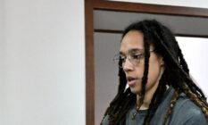 Brittney Griner wears a grey shirt and has her hair in locks as she walks to a preliminary court hearing in Russia