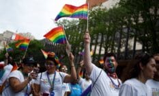 Revelers hold up LGBTQ+ Pride flags as they participate in the Philadelphia LGBT Pride Parade through the city's "Gayborhood" and downtown historic district in Pennsylvania
