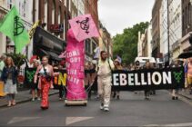 Rainbow Rebellion members march in Soho with a giant pink dildo