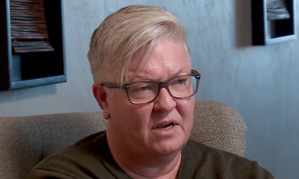 Oklahoma lesbian woman Kris Williams is seen talking to the news while wearing a grey shirt after she was removed from her son's birth certificate