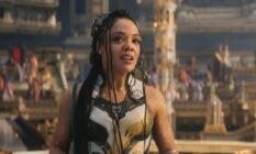 Tessa Thompson wears blue and white patterned armour as she stands in front of a crowded stadium as she plays the character Valkyrie in Thor: Love and Thunder