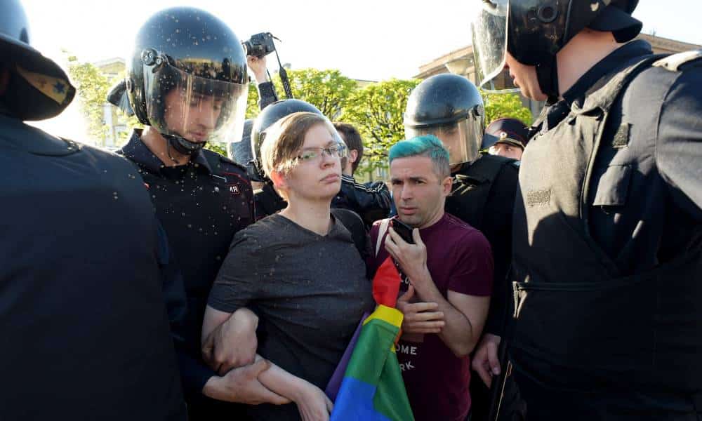 Russian riot police detained gay rights activists holding a LGBTQ+ rainbow flag