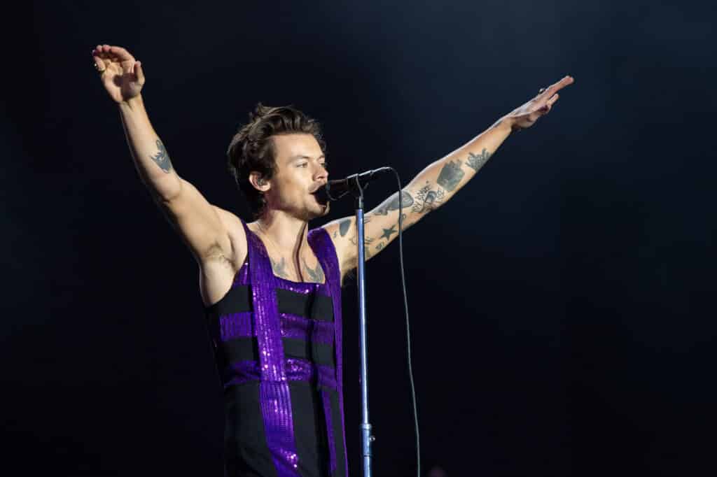Harry Styles performs on the Main Stage at War Memorial Park in a purple sequinned dress