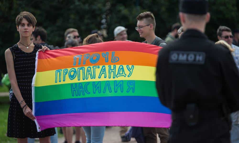 A participant holds a banner with the inscription 'Stop propaganda of violence' during the a LGBTQ+ demonstration in Field of Mars in St. Petersburg