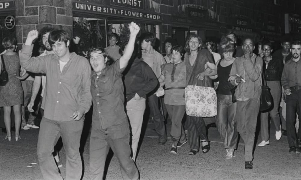 Mark at the Stonewall riots in 1969, pictured at the front with his arm raised.