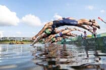 Athetes dive during the mixed relay Triathlon competition at the 2020 Tokyo Olympic Games