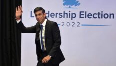 In this photograph, Rishi Sunak waves as he walks across the stage the the Conservative leadership hustings in Perth, Scotland