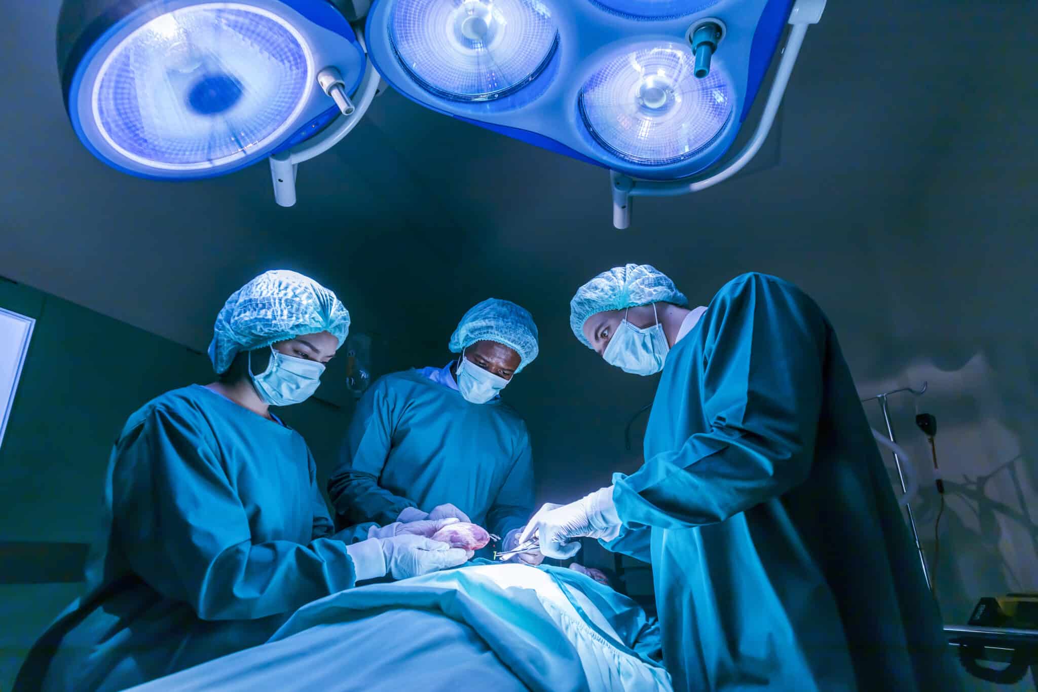 Team of surgeon doctors are performing heart surgery operation for patient