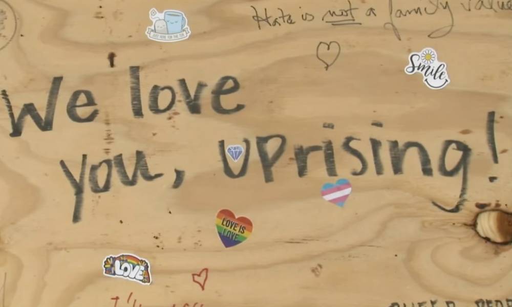 A board on the window of UpRising Bakery and Café reads 'we love you uprising' after the business was vandalised over a planned family-friendly drag event
