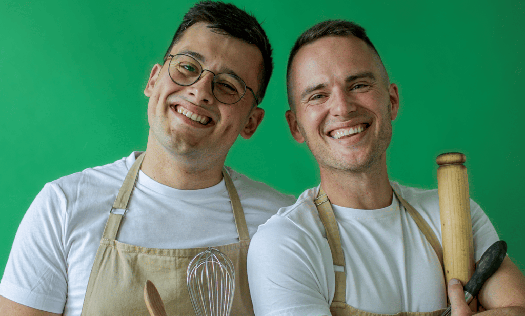 Michael Chakraverty et David Atherton, stars de Great British Bake Off, sourient en posant ensemble