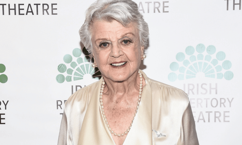 Angela Lansbury wears a white outfit as she smiles for the camera